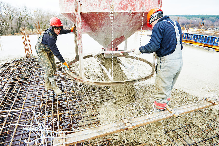 A construction site worker pours concrete into formwork at a building site in Norwalk, Connecticut.